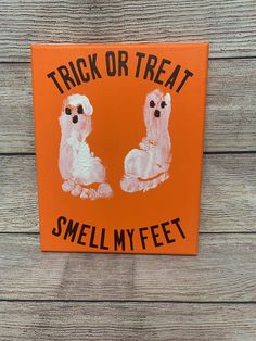 an orange sign that says trick or treat smell my feet with two poodles painted on it