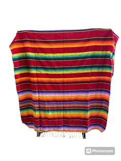 a multicolored blanket is hanging on a rack