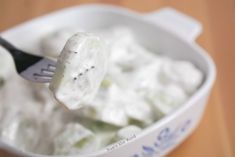 a spoon full of ice cream sitting in a bowl