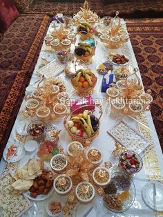 a table filled with lots of food on top of a white tablecloth covered floor