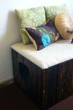 a wooden bench with pillows on top of it