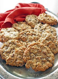 oatmeal raisin cookies on a metal plate with a red napkin in the background