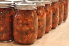 several jars filled with food sitting on top of a wooden table