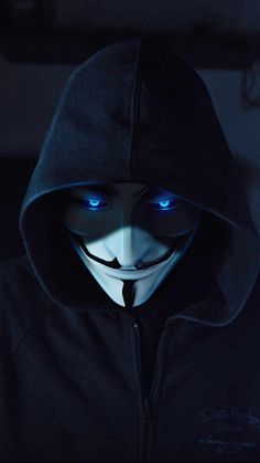 a person wearing a hoodie with blue eyes and a creepy mask on their face