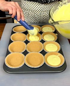 a person is mixing batter into cupcakes on a tray with other muffin tins