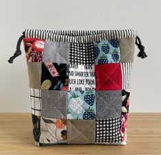 a small patchwork bag sitting on top of a wooden table