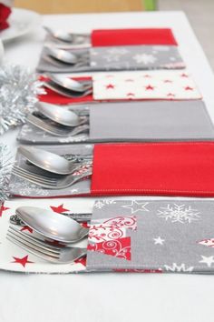 the table is set with silverware and red napkins on it's placemats