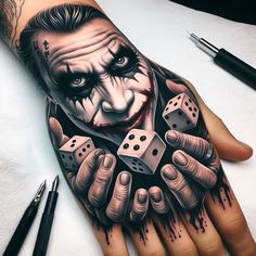 a man's hand with a joker tattoo on it and dices in front of him