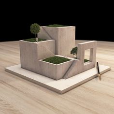 a small tree is growing in the middle of two concrete structures on a wooden table