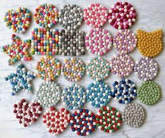 many different colored beads are arranged on a white surface