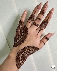 a woman's hand with henna tattoos on it