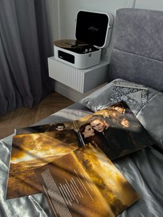 an open magazine sitting on top of a bed next to a record player and other items