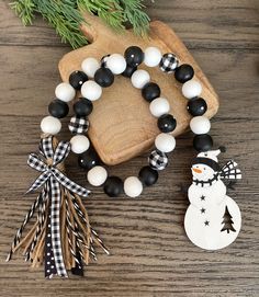 black and white beaded bracelets with snowman ornament on wooden board