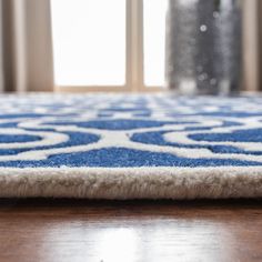 a blue and white rug on top of a wooden floor