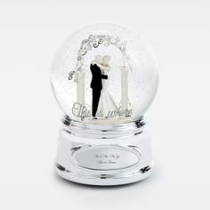 a snow globe with a bride and groom in the middle on it's stand