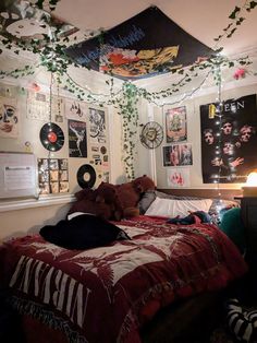 an unmade bed with lots of decorations hanging from the ceiling and lights above it