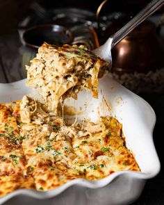 a casserole dish with cheese being lifted from it