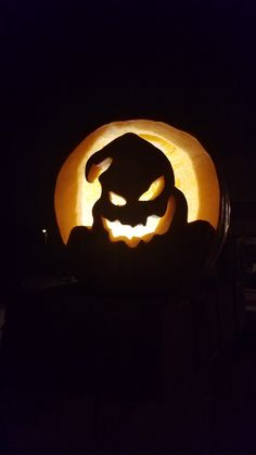 a pumpkin carved into the shape of a cat with its head in it's mouth