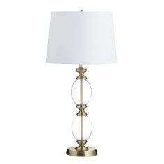 a lamp that is sitting on top of a white table cloth with a gold base