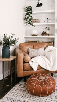 a living room with a brown leather chair, ottoman and potted plants on shelves