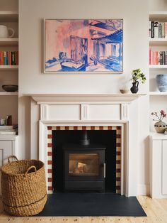 a living room with a fire place and bookshelves on the wall above it