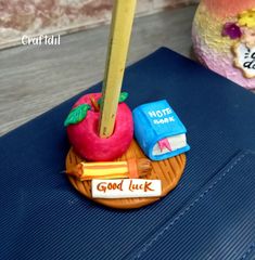 there is a small toy with a pencil in it on top of a blue suitcase