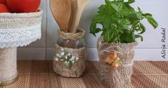 two vases filled with tomatoes and vegetables on top of a table next to a wall