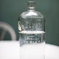 an empty glass bottle sitting on top of a table