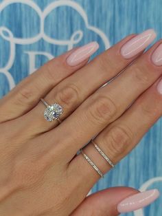 a woman's hand with pink manicured nails and a ring on her finger