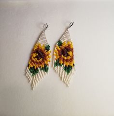 a pair of sunflower seed beaded earrings