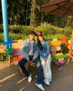 a man and woman sitting on a colorful bench