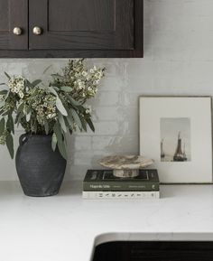 a vase with flowers on top of a counter