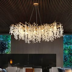 a large chandelier hanging from the ceiling in a room with couches and tables