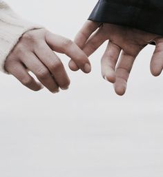 two people reaching out their hands to touch eachother's hand, in black and white