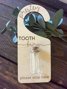 a tooth fairy bottle stopper with eucalyptus leaves on it and the words, tooth fairy please stop here