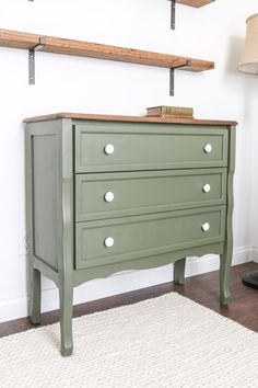 a green dresser sitting in the corner of a room