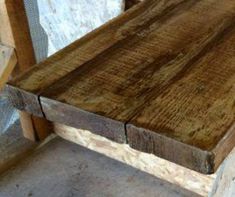 a wooden bench sitting on top of a cement floor