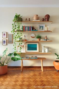 there is a desk and shelves with plants on it in the room that has wood flooring