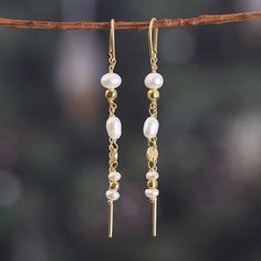 A dance of sophistication and natural grace arrives from the luxurious Indian lands to your hands. Designer Neetu Barathi and master artisans with long years of expertise in the jewelry arts unite forces to bring these threader earrings to life. Composed of cultured pearls in a natural cream hue—symbols of dignity—the accessories boast glorious 18k gold plating. Graceful Gold Dangle Earrings, Graceful Gold Earrings, Graceful Yellow Gold Earrings For Gift, Graceful Yellow Gold Drop Earrings, Elegant Long Drop Jewelry For Celebrations, Graceful Gold Earrings For Anniversary, Yellow Gold Long Drop Pearl Earrings With Ear Wire, Formal Gold Threader Earrings With Pearl Drop, Adjustable Gold Threader Earrings With Pearl Drop