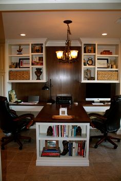 a home office with two desks and bookshelves