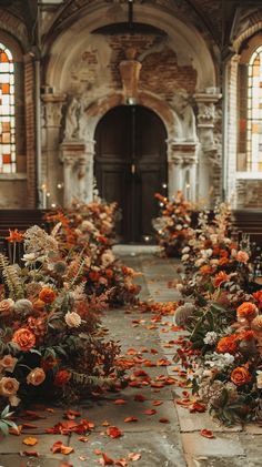 an aisle with flowers and leaves on the ground