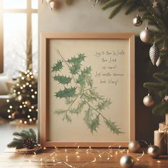 a christmas tree with ornaments around it and a framed print that says, let the world be merry