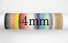 a roll of multicolored beaded bracelets with the word 4 mm on it