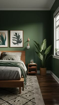 a bedroom with green walls and wood floors, two paintings on the wall above the bed