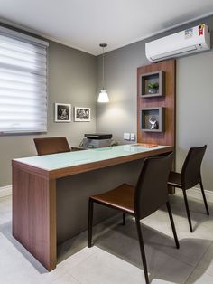 an office with a desk, chair and air conditioner on the wall above it