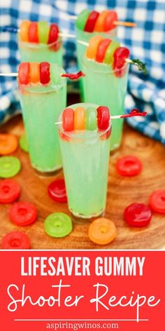 three glasses filled with green liquid and candy on top of a wooden tray that says lifesaver gummy shooter recipe