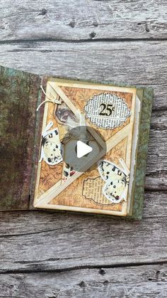 an open book on top of a wooden table next to a piece of paper and scissors