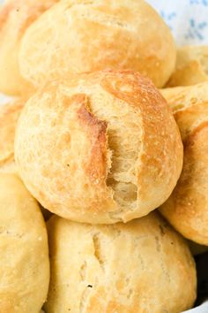 a pile of bread rolls sitting on top of a blue and white cloth covered bowl