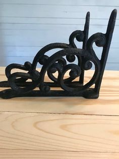 a black metal object sitting on top of a wooden table next to a white wall