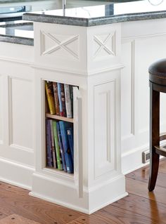 a kitchen island with bookshelves and stools